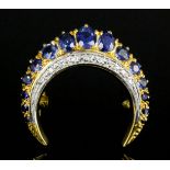 An 18ct gold mounted sapphire and diamond set crescent pattern brooch, the ten oval cut sapphires of