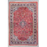 A Persian rug of Kashan design woven in colours with a central floral filled medallion and