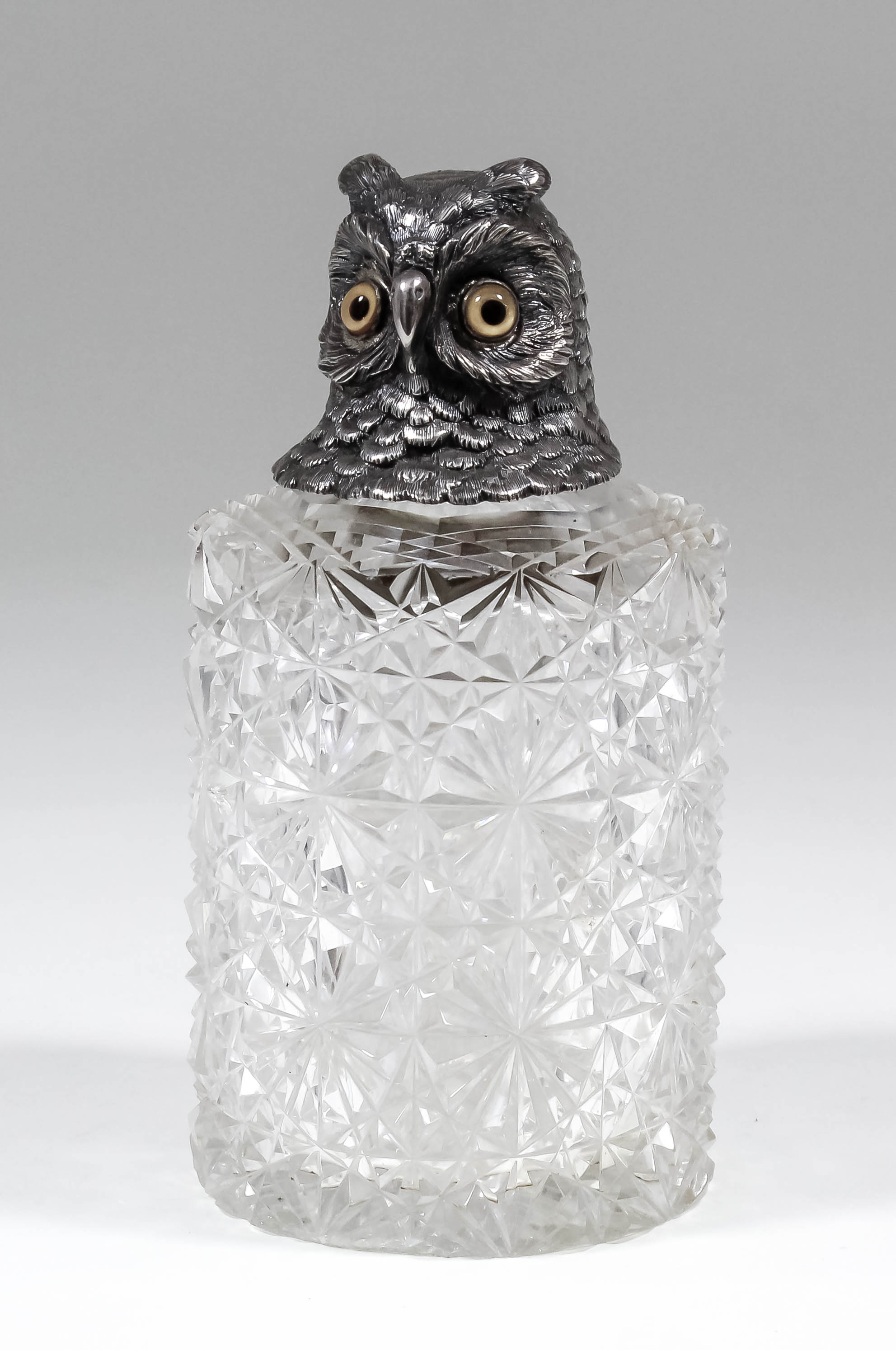 A Victorian silver topped and slice cut-glass cylindrical scent bottle, the cover cast in the form