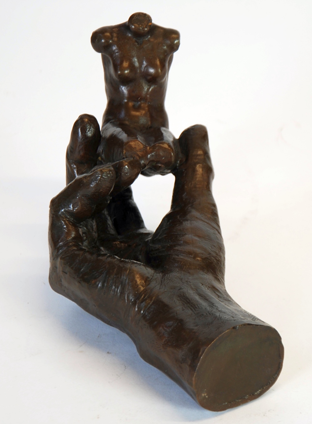 MODERN DALIESQUE PATINATED BRONZE MODELLED AS A HAND SUPPORTING A FEMALE TORSO, 8 1/2" (21.6cm) long