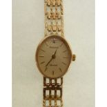 LADY'S ACCURIST 9CT GOLD CASED WRIST WATCH, quartz movement, the oval dial with gilt batons and