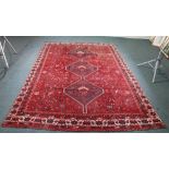 CAUCASIAN CARPET.  With triple pole medallion in midnight blue, on a dark wine red field  with an