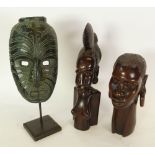 TWO WELL CARVED AFRICAN EBONY FEMALE BUSTS, and a SIMILAR WALL MASK on stand, 14" (35.6cm) high