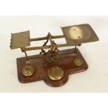 PAIR OF EARLY TWENTIETH CENTURY BRASS POSTAL SCALES, in mahogany base with boxwood stringing lines