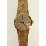LADYS OMEGA 9CT GOLD WRIST WATCH, mechanical movement, silvered dial with gilt batons, on integral