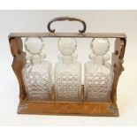 BETJEMANNS PATENT OAK TANTALUS, with electroplated mounts WITH THREE CUT GLASS DECANTERS, 14" x