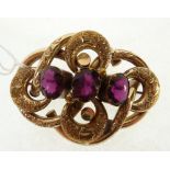 VICTORIAN PASTE SET PINCHBECK KNOT BROOCH, foliate engraved with three graduated purple paste