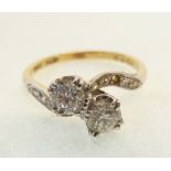 TWO STONE DIAMOND CROSSOVER RING, double claw set with two round brilliant cut diamonds, each 0.