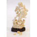 JAPANESE ONE PIECE CARVED IVORY FIGURE OF A DEITY, smiling, standing on one leg on top of a