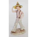 LATE GOLDSCHEIDER POTTERY FIGURE modelled as a striding boy wearing a conical hat, 9" (22.8cm) high,