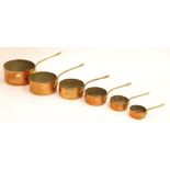 GRADUATED SET OF SIX COPPER SAUCEPANS WITH BRASS HANDLES