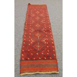 EASTERN HAND KNOTTED ALL-WOOL PILE RUNNER, crimson with black stencilled pole medallion pattern with