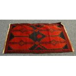 EASTERN HAND KNOTTED ALL-WOOL PILE RUG, with black star burst design on a crimson field, two