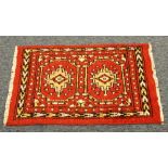 EASTERN HAND KNOTTED ALL-WOOL PILE RUG, with two large yellow medallions on a red field, narrow