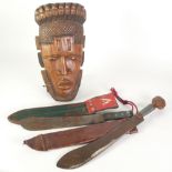 CARVED WOOD TRIBAL MASK, 18" (45.7cm) long, A MACHETE WITH CARVED WOOD FIGURAL POMEL AND LEATHER