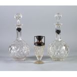 PAIR OF CUT GLASS DECANTERS OF GLOBE AND SHAFT FORM WITH STOPPER, the necks with silver coloured
