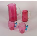 FOUR PIECES OF VICTORIAN AND LATER CRANBERRY GLASS, COMPRISING; TWO TAPERING JUGS, with clear