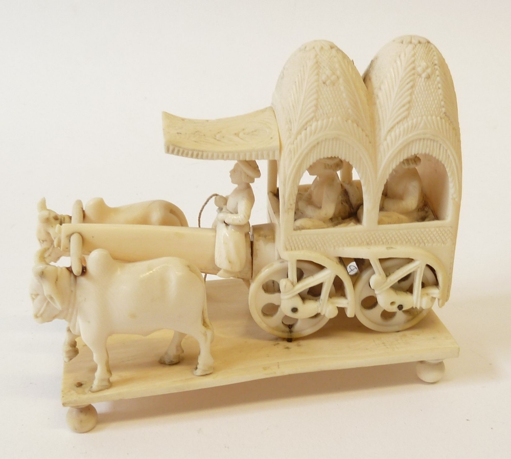 EARLY TWENTIETH CENTURY CARVED IVORY GROUP OF AN OX-DRAWN CART CARRYING TWO FIGURES, WITH DRIVER,