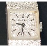 LADY'S 9CT WHITE GOLD WRIST WATCH, 17 jewel movement, square textured silver dial with batons,