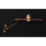 GOLD OWL BAR BROOCH, the bi-coloured gold owl with emerald cabochon eyes, perched on the bar,