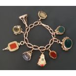 9CT GOLD CURB LINK BRACELET WITH NINE HARDSTONE FOBS, including a watch key set with carnelian