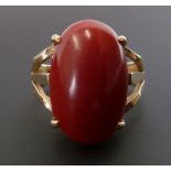 CORAL RING, four claw set with large oval coral, 5.7cm long, with pierced shoulders, stamped 14k