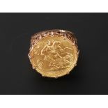 GEORGE V GOLD HALF SOVEREIGN, MOUNTED AS A RING IN 9CT GOLD, with pierced scroll shoulders,