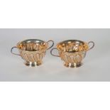 PAIR OF VICTORIAN SILVER TWO HANDLED CIRCULAR SMALL BOWLS, repousse with spiral lobes, 2 1/4"