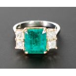 EMERALD AND DIAMOND RING, central emerald 3.55ct, flanked each side by two princess cut diamonds,