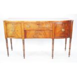 GEORGE III FIGURED MAHOGANY AND EBONY LINE INLAID BOW FRONTED SIDE BOARD, the shaped top above a