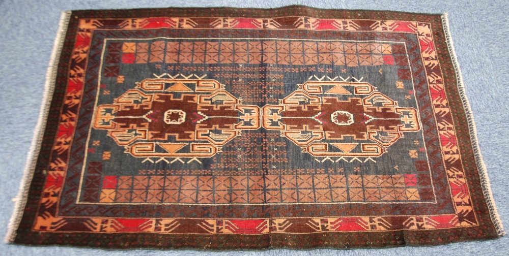 EASTERN RUG, with two large medallions and two side panels, on a dark brown field and three narrow
