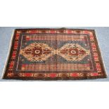 EASTERN RUG, with two large medallions and two side panels, on a dark brown field and three narrow