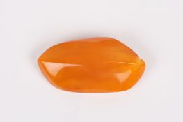 A Baltic amber brooch, of asymmetric slightly raised form and of butterscotch colour, length 7cm .
