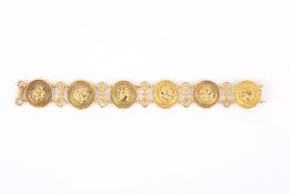 A Chanel style yellow metal bracelet, formed as six roundels each with applied floral centres, and