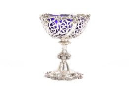 A Victorian pierced silver bon-bon dish with blue glass liner, hallmarked London 1865, the rim