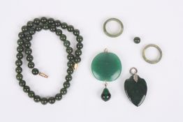 A collection of costume jewellery, including nephrite beads, nephrite pendant and two jade rings .