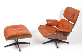 A Charles and Ray Eames rosewood and orange leather lounge chair and ottoman, models 670 and 671