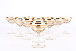 A collection of 11 gilt and clear glass champagne glasses, circa 1930s, with gilt banded bodies