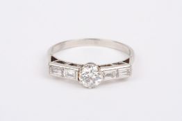 An Art Deco platinum and diamond ring, set with central diamond of approximately 0.3cts set with