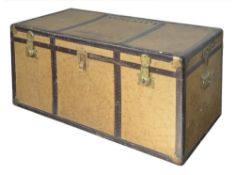 A large beige and brown travelling trunk, with three brass locks opening to reveal an upper