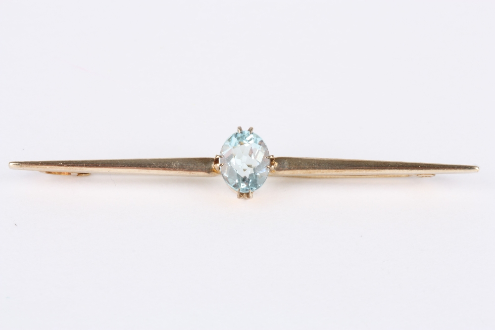 A 9ct gold and aquamarine bar brooch, with an oval claw-set aquamarine on a tapering bar, stamped