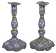 A pair of late 19th century Canton enamel candlesticks, decorated with flower panels and lotus