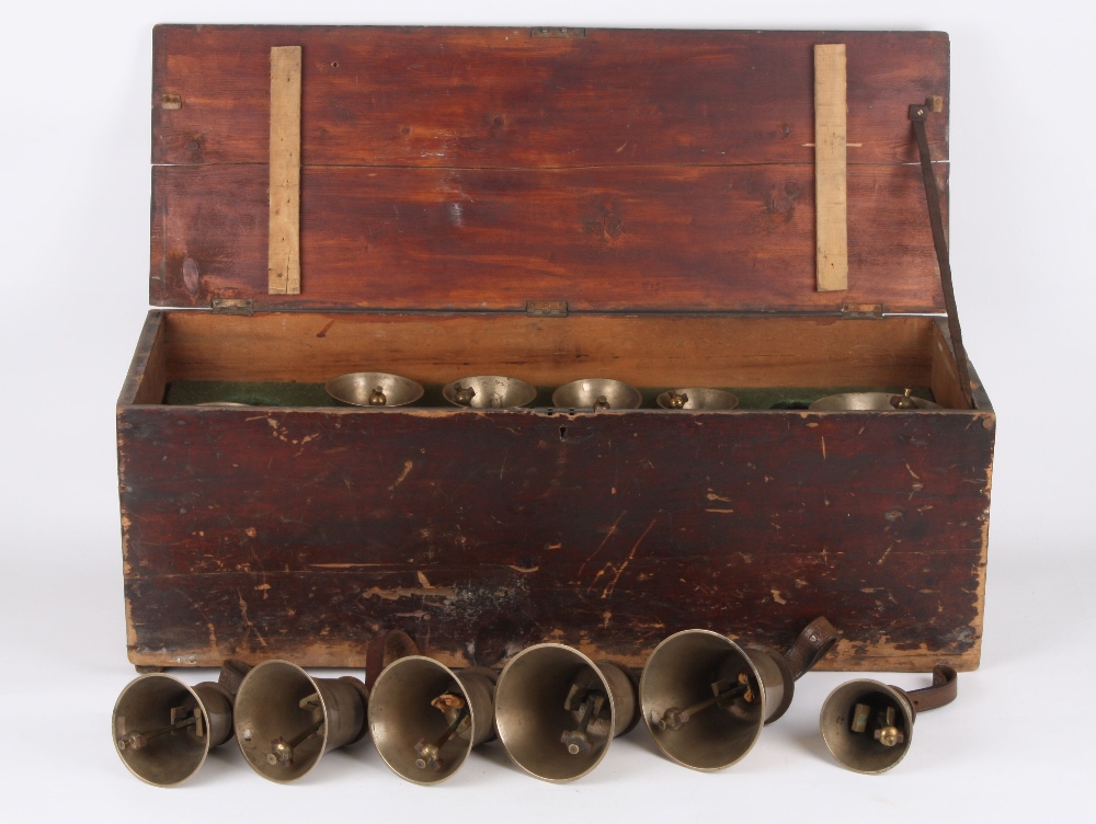 A set of twelve graduated brass hand bells, early 20th century each with leather strap and stamped