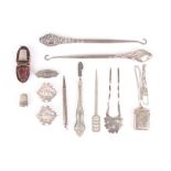 A small collection of silver items, including two button hooks, two thimbles, three brooches, two