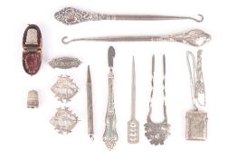 A small collection of silver items, including two button hooks, two thimbles, three brooches, two