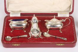 A silver three piece cased cruet set, hallmarked Birmingham 1963, comprising mustard pot, salt and