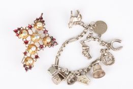 A silver charm bracelet set with ten charms, together with a gilt metal crucifix set with pearls and