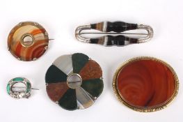 Five assorted brooches including agate brooches, comprising four agate brooches one of flower form