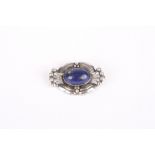 A Georg Jensen Sterling silver brooch, set with oval cabochon lapiz lazuli stone, the mount formed