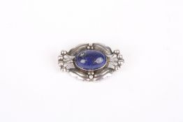 A Georg Jensen Sterling silver brooch, set with oval cabochon lapiz lazuli stone, the mount formed